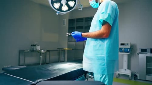Nahaufnahme eines Arztes in einer speziellen Uniform, der Instrumente vor dem Operationssaal vorbereitet