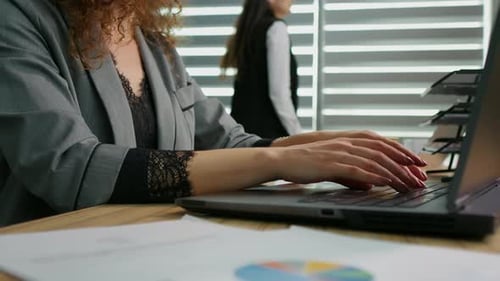 Businesswoman hands typing on laptop working online in office.