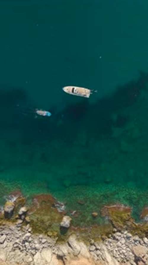 Aerial View of Boats Near Rocky Coastline
