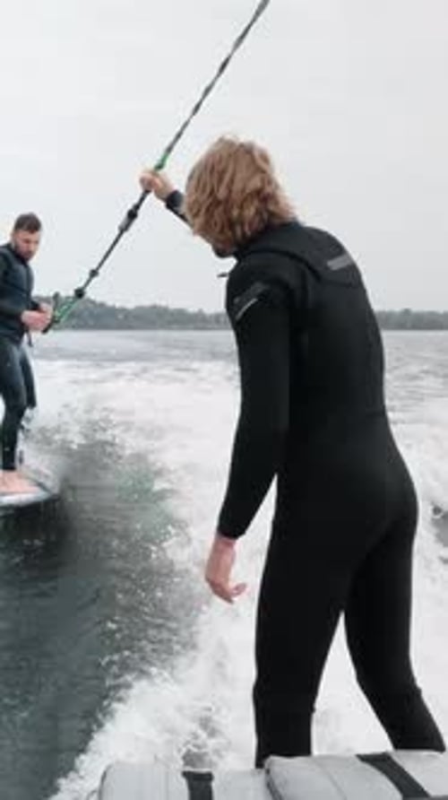 Two Surfers Engaging in an Exciting Water Sport Adventure Riding the Waves on a Surfboard While