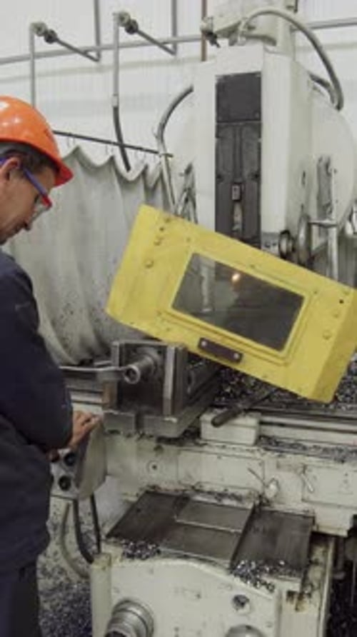 Factory Worker Operating Milling Machine Producing Metal Shavings Stock Clip