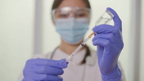 The Doctor Fills the Syringe With the Vaccine in Preparation for the Injection
