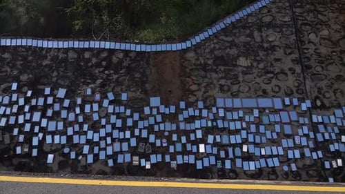 Hundreds of mirrors hanging on rock beside rode for prayer, Nepal