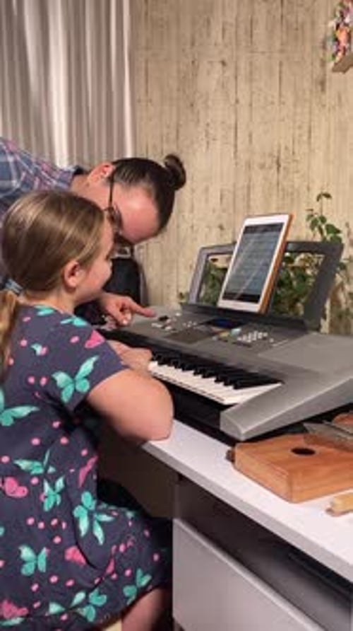 Girl Learning Piano with Teacher at Home