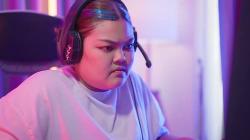 Person Gaming on Computer with Headset