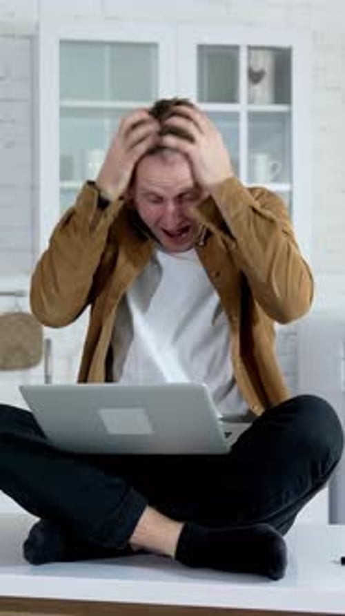 Frustrated Man Working on Laptop While Sitting