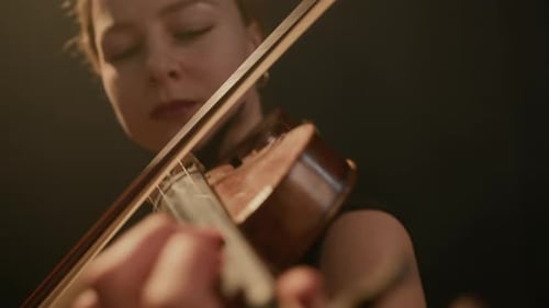 Woman Playing Violin with Warm Lighting