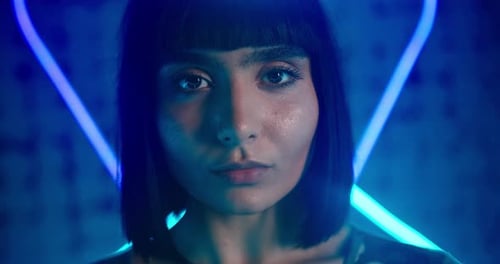 Cyberpunk Lady Looks Into Camera Emotionlessly in Neon Light