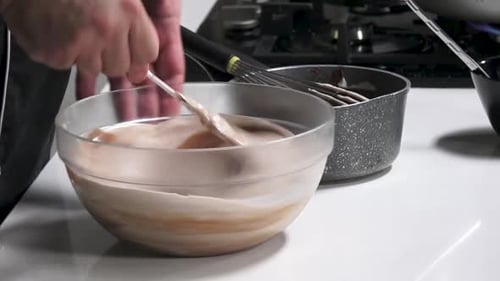 Man mixing delicious chocolate dessert in clear bowl