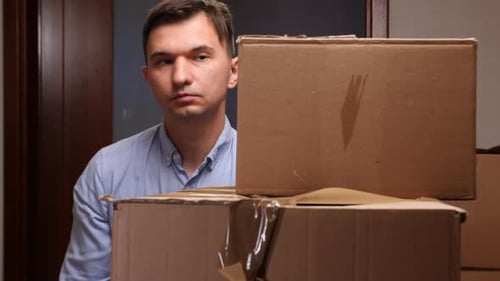 Man Stacking Boxes Indoors