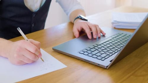 A Top View Shot of a Man's Hands Holding a Pen and Writing on a Paper