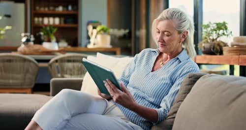 Woman Relaxes Indoors Using Tablet on Couch