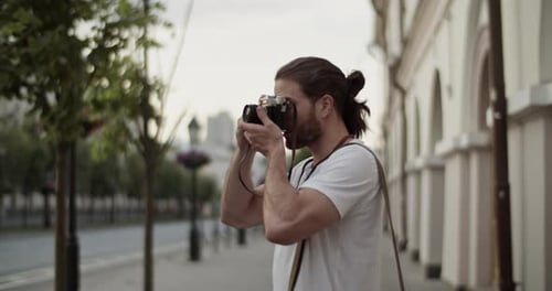 Smiling Male Tourist Photographing City on Film Camera During Trip