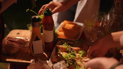 Forming Readytoeat Hot Dogs on the Table During an Outdoor Party with Friends Party Food Concept
