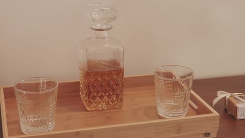 Carafe en cristal avec whisky sur plateau en bois