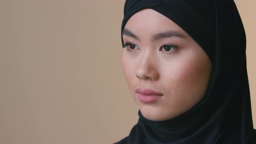 Close-Up of Young Woman in Black Headscarf
