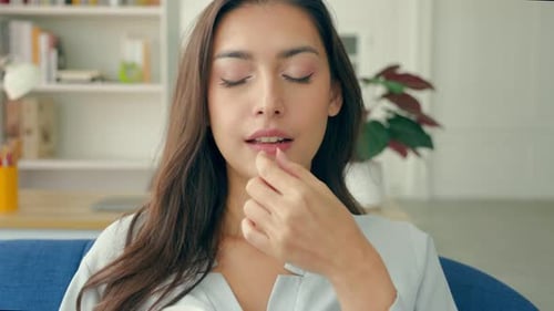 Young Woman Taking Pill with Water Indoors