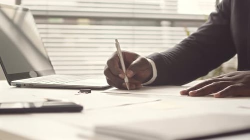 Businessman Signing Papers in Office