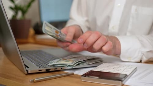 Man Settling Accounts Tax Calculation and Counting Money Dollars Cash Close Up