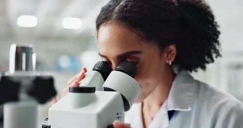 Woman Scientist Using Microscope in Laboratory