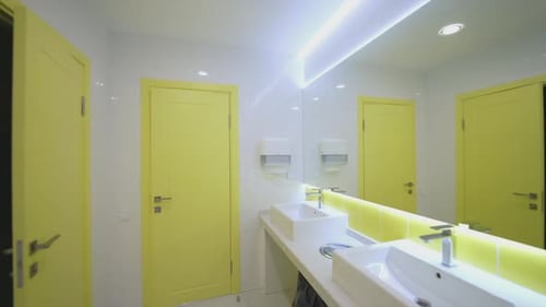 Modern toilets in clinic. White and yellow sterile water closet with wash basins in the hospital.
