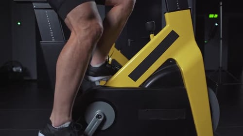 Man Training on a Spin Bike Performs Aerobic Endurance Training on the Simulators in the Gym Cycle