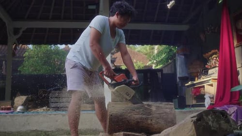 Balinese Wood Carver Cutting Woods Using Chainsaw. - wide shot