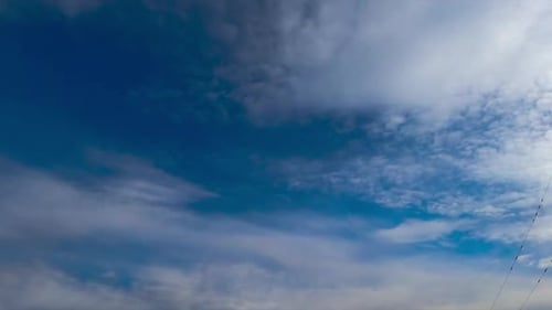 Soft light clouds quickly flowing by the horizon. Heavy grey clouds changing soft ones.