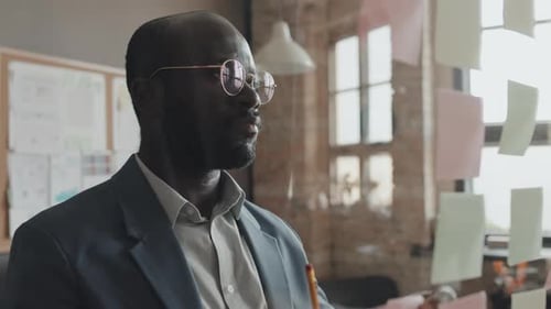 Man Planning with Sticky Notes on Glass Wall