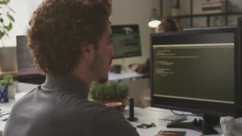 Male Programmer Writing Code on Desktop Computer