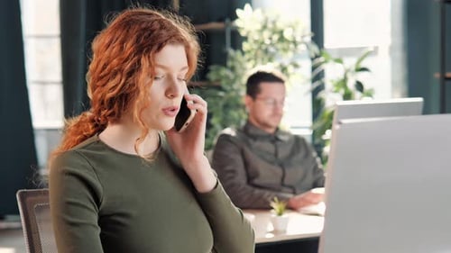 Woman Talking on Cellphone at Her Workplace