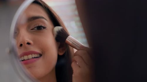 Young Woman Applies Makeup With Brush in Mirror