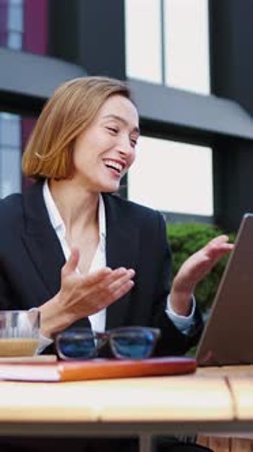 Smiling Businesswoman Video Calling on Laptop Outdoors