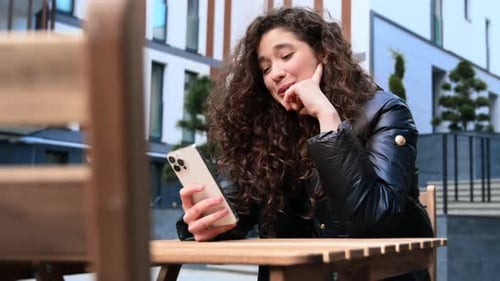 Woman using phone while sitting outdoors