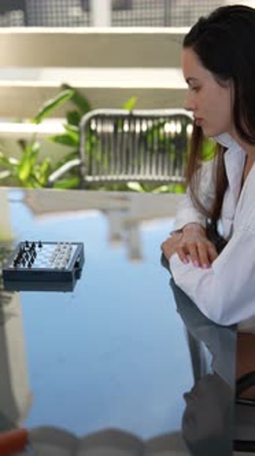 Reflect on a Modern Office Environment with an Outdoor Chess Match Happening at a Table