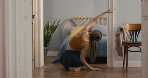 Rear View of Girl in Yellow Top Doing Stretching and Yoga at Home Girl Stretches Her Hand to the