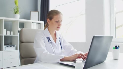 Doctor Works in the Medical Office Woman in White Coat Workplace of a Professional Female Therapist