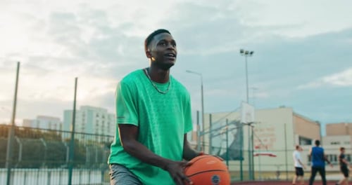 Bel homme en tenue de sport élégante jouant au basket à Blayground avec des amis