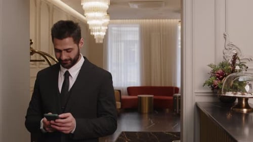 Businessman Using Smartphone at Hotel Lobby