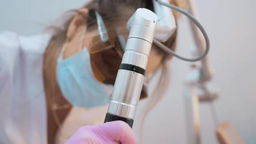 Cosmetologist Removes a Tattoo to a Patient Using a Neodymium Laser in a Modern Clinic