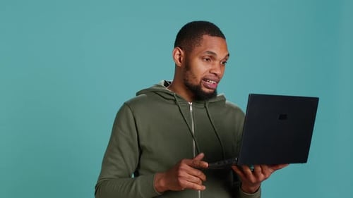Man Video Conferencing on Laptop Waving and Talking
