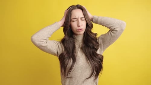 Woman Experiencing a Headache, Holding Head in Pain
