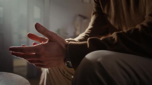 Man Moves Palms at Conversation with Psychologist at Semidarkness