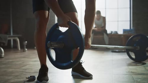 Close-up on Hands: Bodybuilder Puts Additional Weights on a Barbell. Muscular Fit People Training,