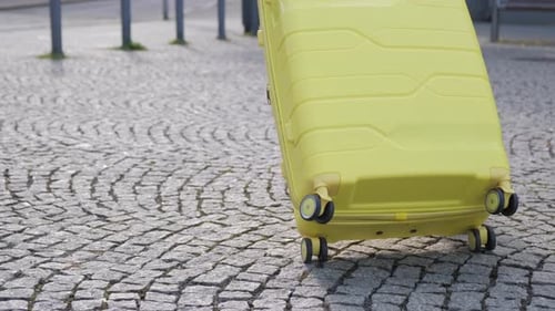 Slow Motion of a Female Tourist Walking Down the Street and Carrying a Suitcase