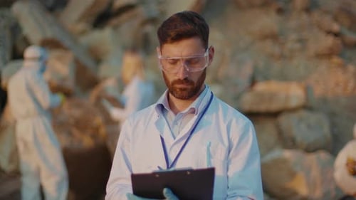 Man with Clipboard Studying Outdoor Rocky Setting