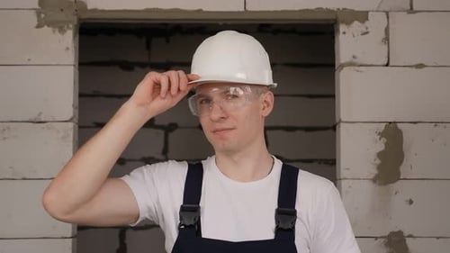 Portrait of a Male Construction Worker in a Helmet Overalls and Goggles