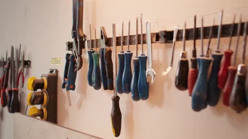 Chisels Screwdrivers Wrench and Pliers on Wall in Furniture Assembly Shop