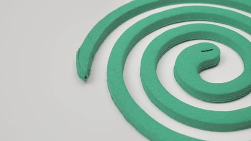 Spirale à moustiques tournant sur un moulinet sur fond blanc