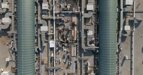 Industrial building rooftops with vents and pipes lined across, Top down view